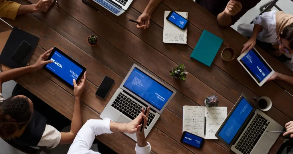 Business company sitting in a meeting with their computers open