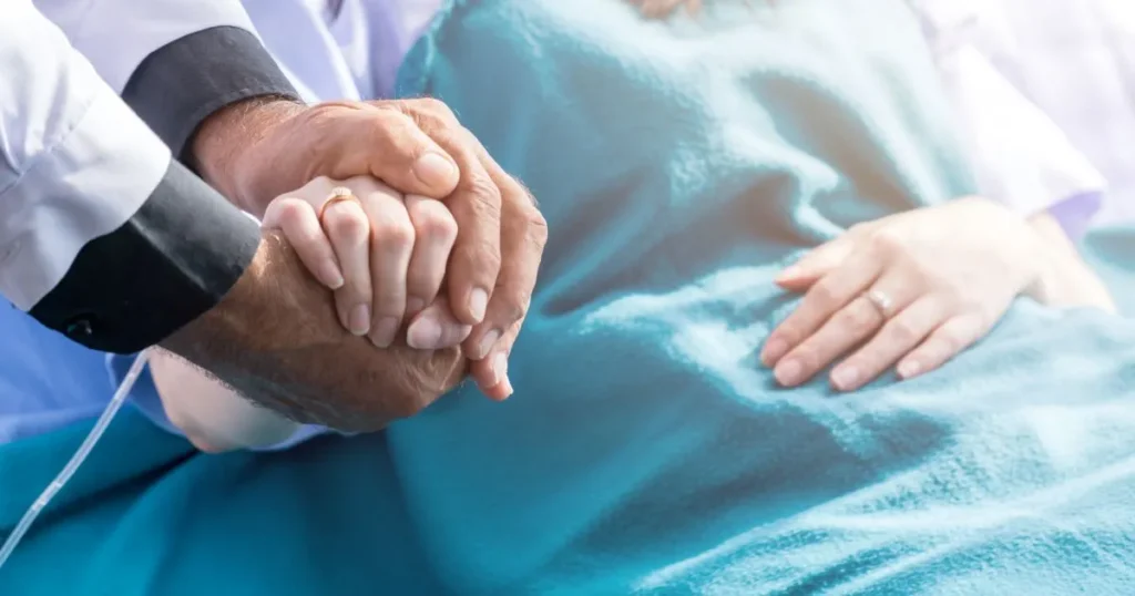 Hospital patient holding doctors hand