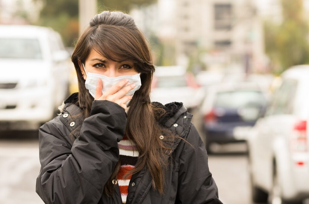 young girl walking wearing a mask in the city street concept of