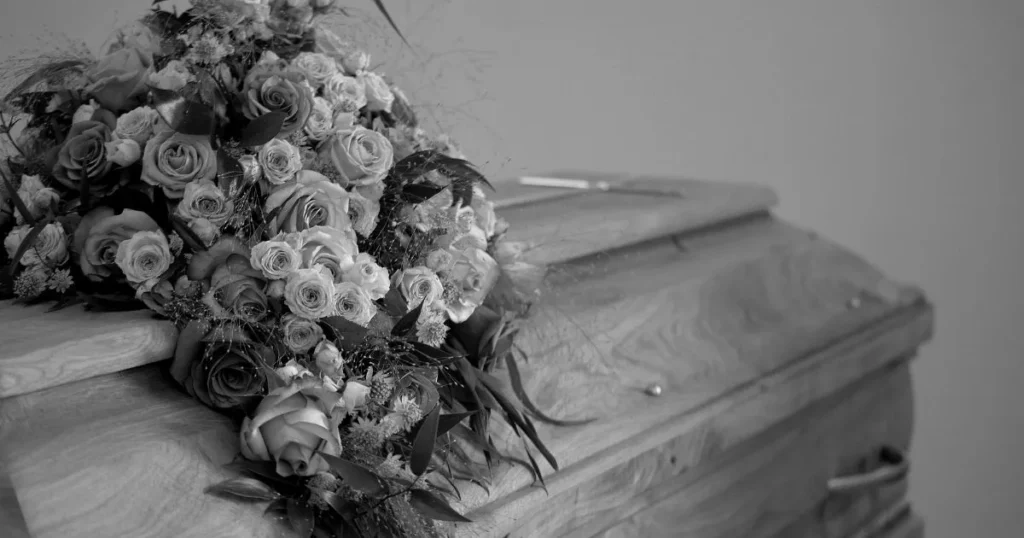 Casket with flowers on top of it