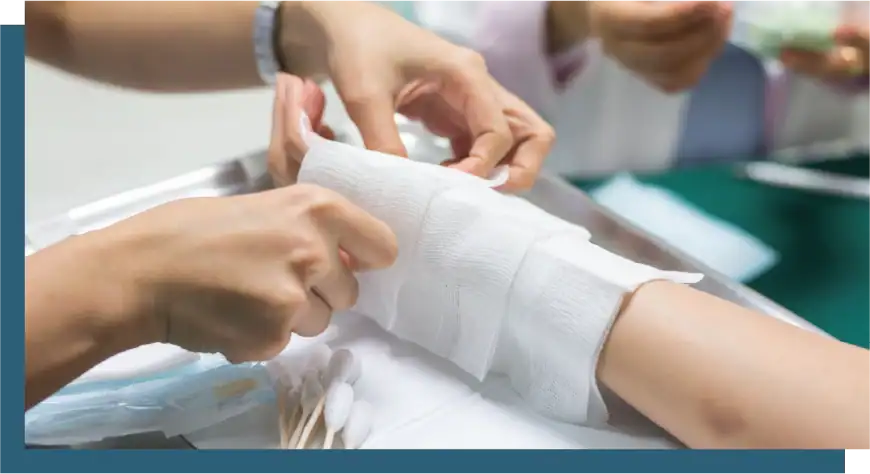 Medical professionals applying a bandage to a patient's arm in an emergency setting.
