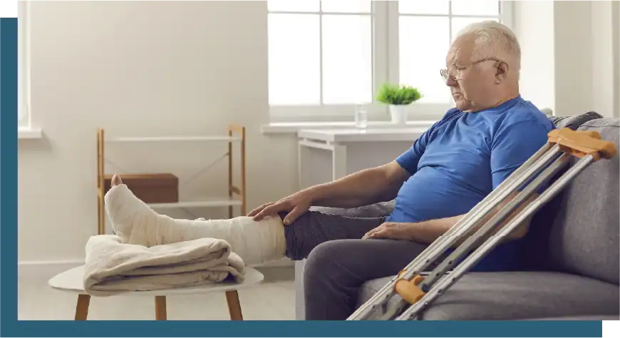 Elderly man receiving injury rehabilitation therapy at home.
