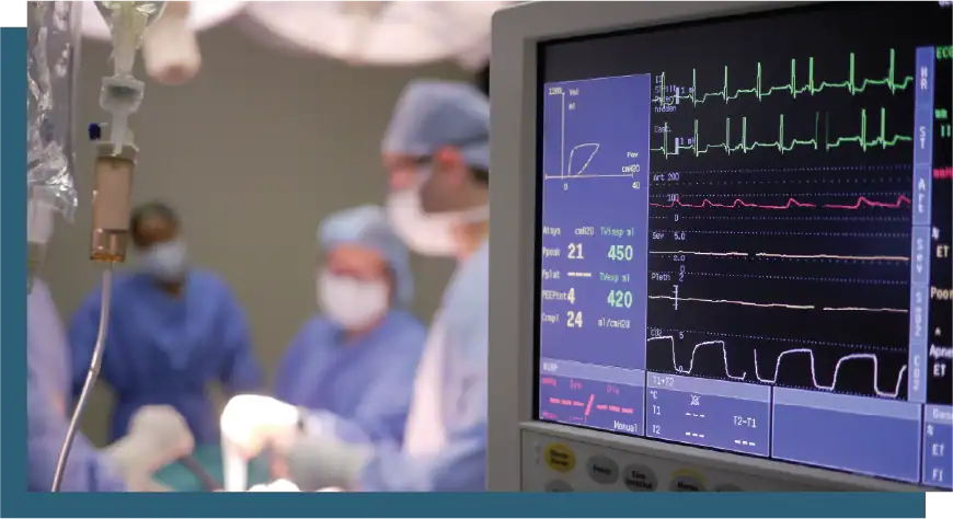 Monitoring patient heart activity with medical equipment during surgery.
