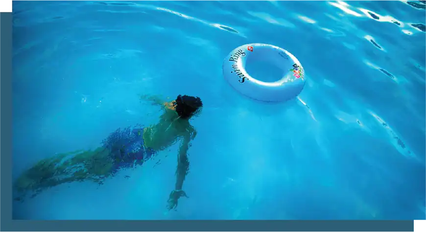 Child swimming in a pool with a life ring for safety and fun.