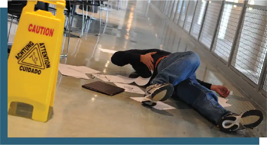 Emergency spill cleanup worker lying on the floor after a slip accident.