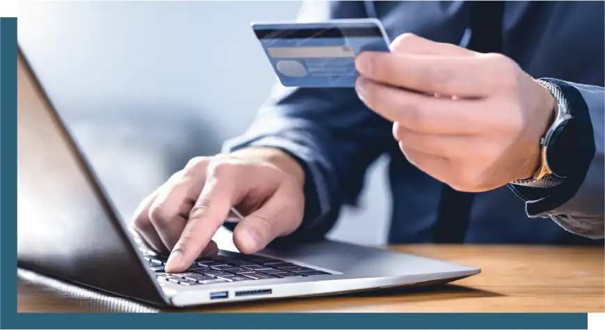 Person making an online payment using a credit card and laptop.