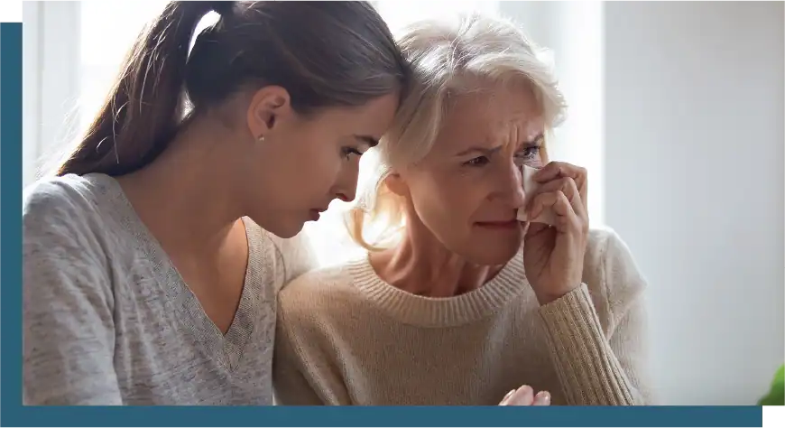 Elderly woman receiving emotional support from caregiver.