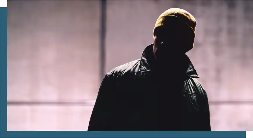 Silhouette of a man with a jacket, backlit and shadowed, emphasizing mystery and anonymity.