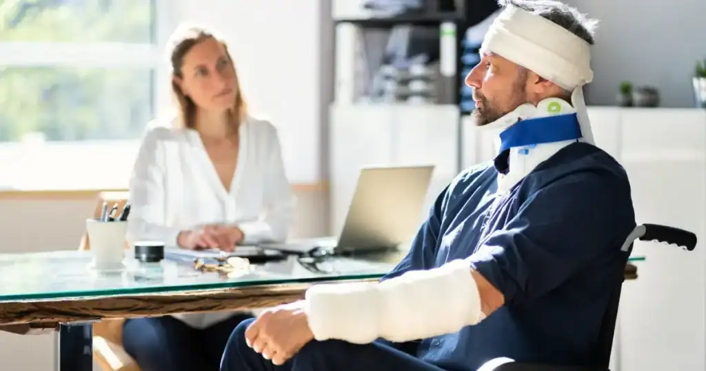 Injured man with head bandage consulting with lawyer in office.