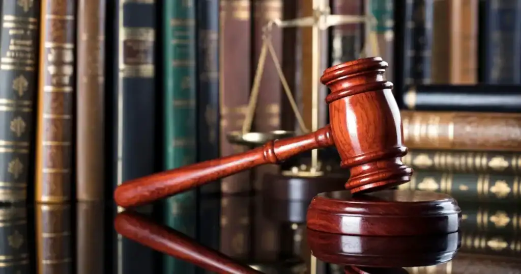 Gavel and scales of justice in a law library setting.