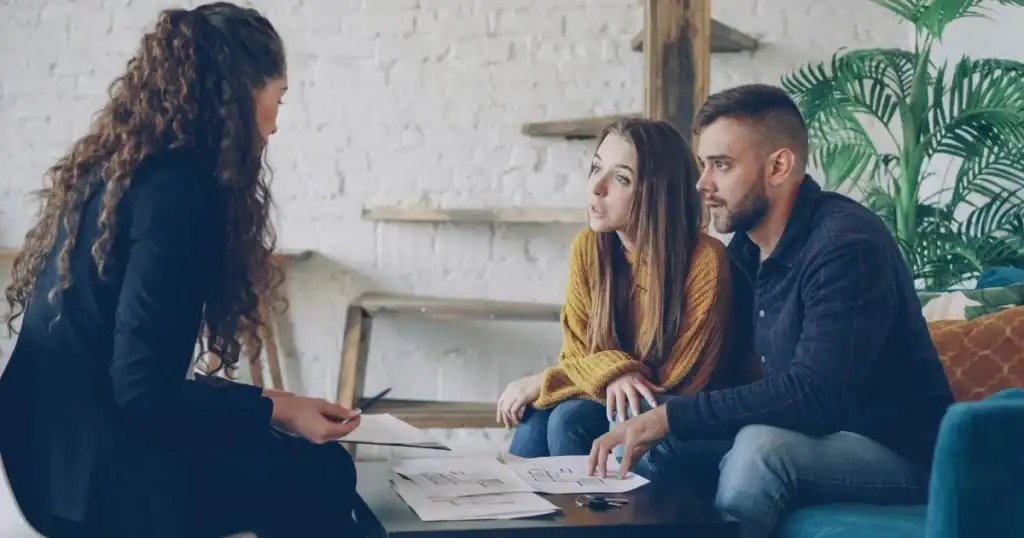 Lawyer consulting with a couple during a free injury consultation.